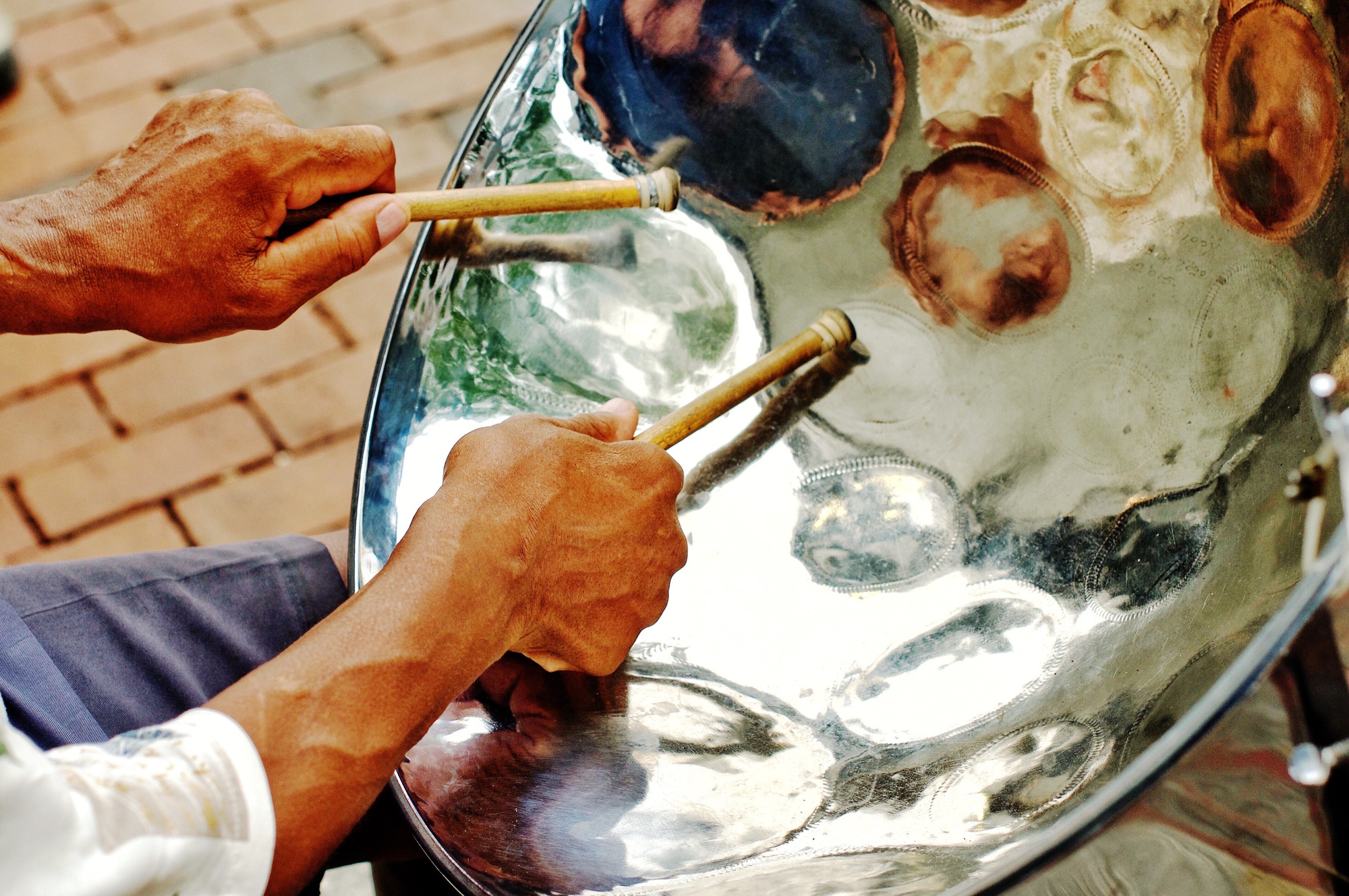 Cheerful sounding Jamaican steel drum player on the city sidewalk